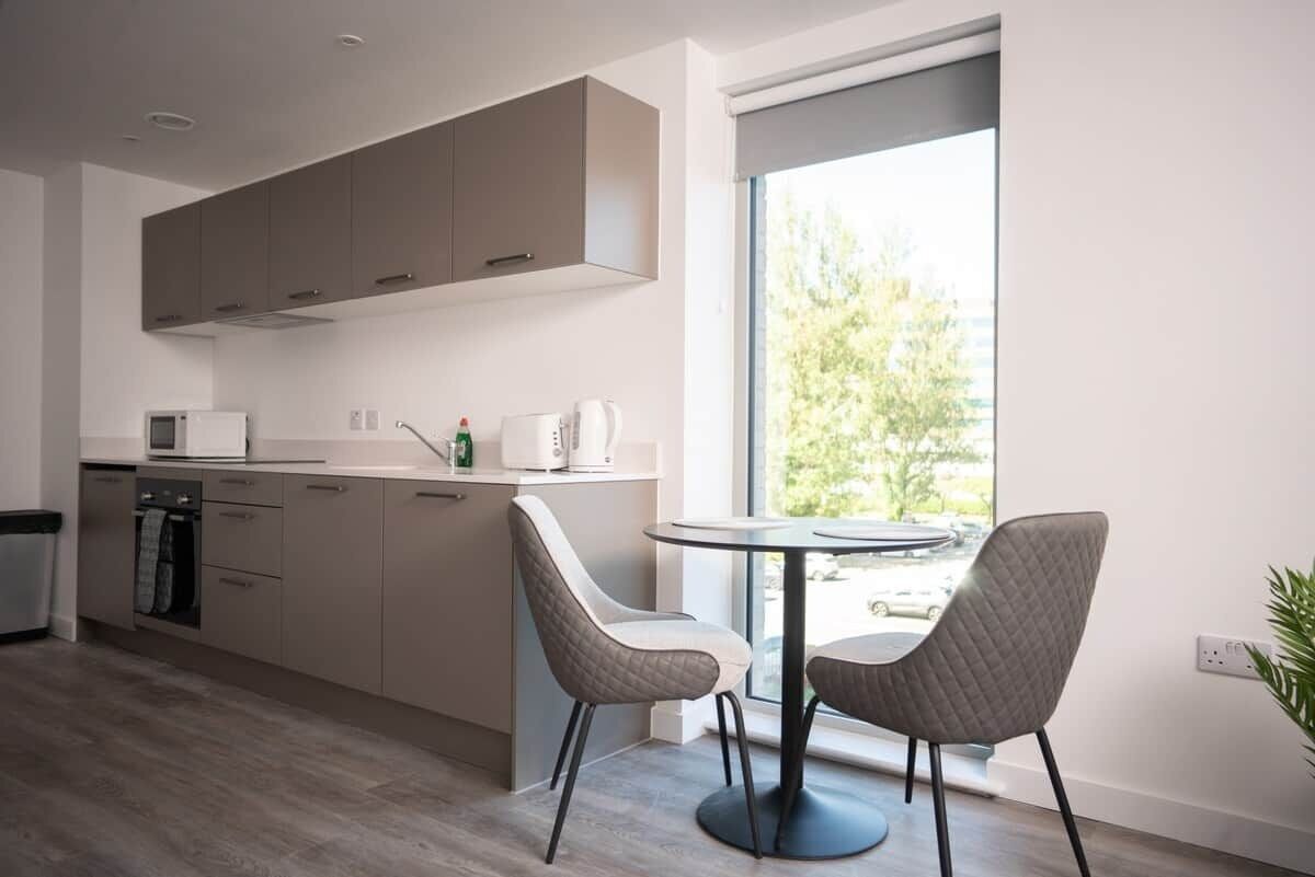 Una cocina moderna con comedor, un ventanal y vistas al exterior.