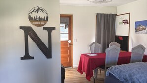 Et værelse med et stort 'N' på væggen, en loftventilator, et spisebord med stole og en seng.