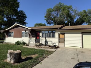 Ein eingeschossiges Haus mit Veranda, Garage und Briefkasten.