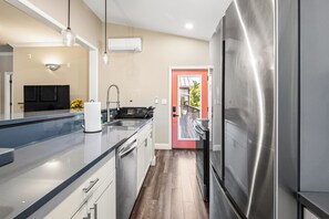 A modern kitchen with stainless steel appliances, a built-in oven, and a large refrigerator. - FUN TIMES LUXURY RESORT-3BD/2BA-LAKEFRONT-POOL-ARCADE-PLAYAREA-DOG AREA-MARINA (Jacksboro)