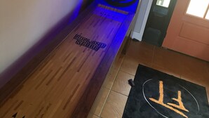 Eine hölzerne Bank mit einem Neonlichtschild mit der Aufschrift 'ROLLAND SCORE' und einer schwarzen Matte mit einem weißen Symbol.