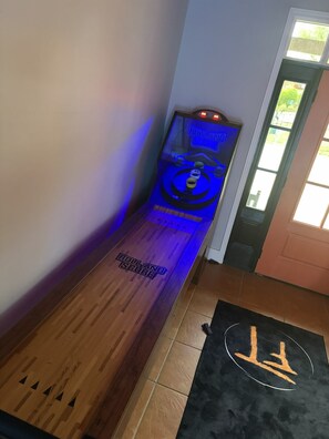 Eine hölzerne Bank mit einem Neonlichtschild mit der Aufschrift 'ROLLAND SCORE' und einer schwarzen Matte mit einem weißen Symbol.