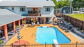 En bostadsfastighet med en swimmingpool, utomhusmöbler och en täckt uteplats.