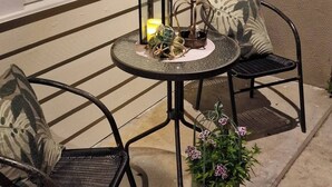An outdoor seating area with two chairs, a table, a lantern, and a potted plant. - Room-cozy Room at Hilde & Tuti (Nærøysund)