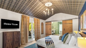 A bedroom with a bed, a TV, a wardrobe, and a sliding door to a bathroom. - Starry Skies: Sauna, S'mores & Pickleball Retreat (Blue Ridge)