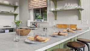 A kitchen with a marble countertop, a wooden bowl, and a window with blinds. - Starry Skies: Sauna, S'mores & Pickleball Retreat (Blue Ridge)