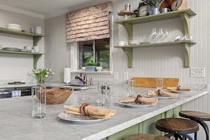 A kitchen with a marble countertop, a wooden bowl, and a window with blinds. - Starry Skies: Sauna, S'mores & Pickleball Retreat (Blue Ridge)