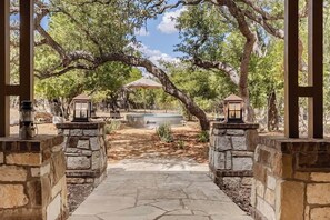 A stone pathway leading to a gazebo with lanterns, surrounded by trees and a barbecue area. - Luxury Estate Spa Bathroom, Observation Deck, Pool (Driftwood)