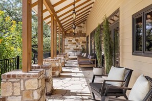 An outdoor covered patio with stone pillars, wooden beams, and seating areas. - Luxury Estate Spa Bathroom, Observation Deck, Pool (Driftwood)