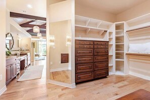 Quarto espaçoso com uma grande cômoda de madeira, estantes embutidas e um closet.