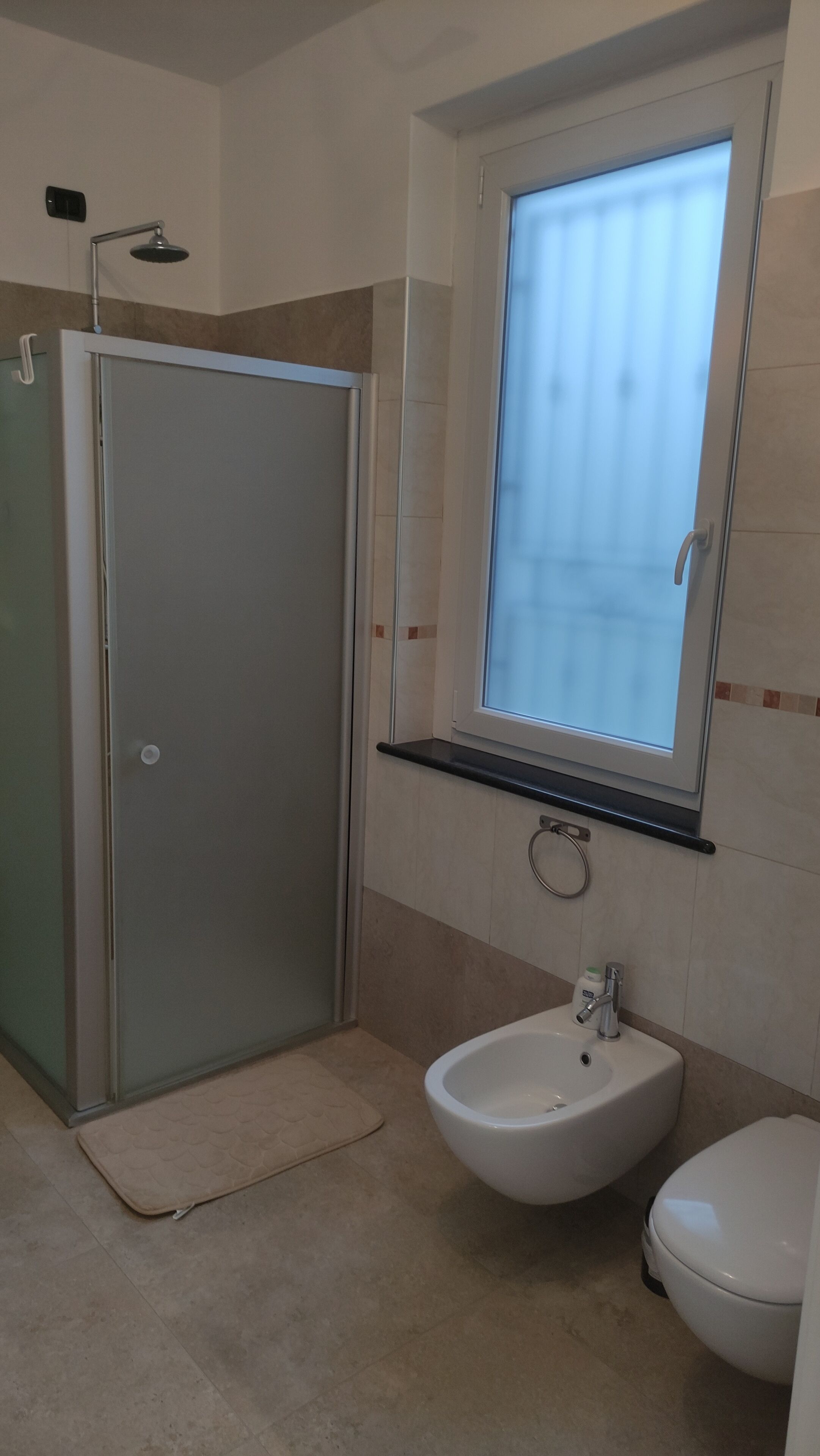 Ein Badezimmer mit Dusche, Waschbecken und Toilette.