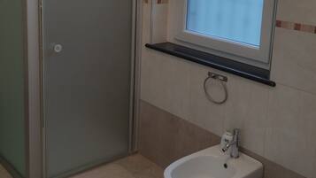 Ein Badezimmer mit Dusche, Waschbecken und Toilette.