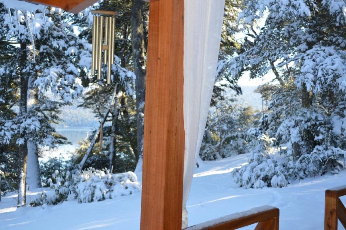 Una estructura de madera con un paisaje nevado al fondo.
