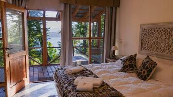 Ein Schlafzimmer mit einem Bett, Kissen und Blick ins Freie.