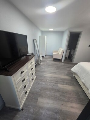 A bedroom with a bed, a TV, a dresser, a chair, and a wardrobe. - Welcome to Modern Maison 

Tranquil studio apartment located in beautiful Nevis (Nevis)
