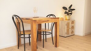 A dining table with four chairs, a candle, and a potted plant. - Unique Chalet, Mountain View, Terrace, Gstaad (Château-d’Œx)