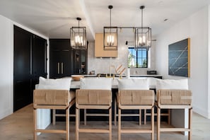 A modern kitchen with a central island, bar stools, pendant lighting, and a view of the outdoors. - Gorgeous 3-bedroom 3-bath (Park City)