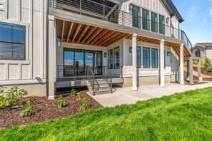 A modern two-story house with a covered porch, large windows, and a visible staircase. - Gorgeous 3-bedroom 3-bath (Park City)