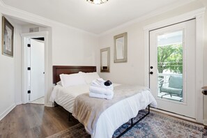 Ein Schlafzimmer mit Bett, Tür, Fenster und Teppich.