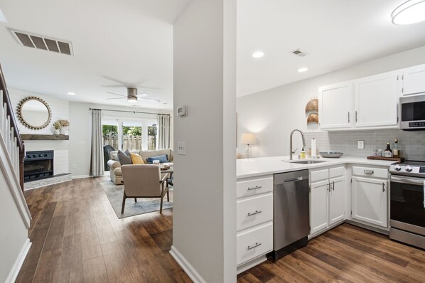 A modern kitchen with white cabinets, stainless steel appliances, and a dishwasher. - Minutes to Wrightsville Beach, Downtown & UNCW (Wilmington)