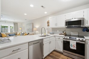 A modern kitchen with white cabinetry, a stainless steel microwave, and a gas stove. - Minutes to Wrightsville Beach, Downtown & UNCW (Wilmington)