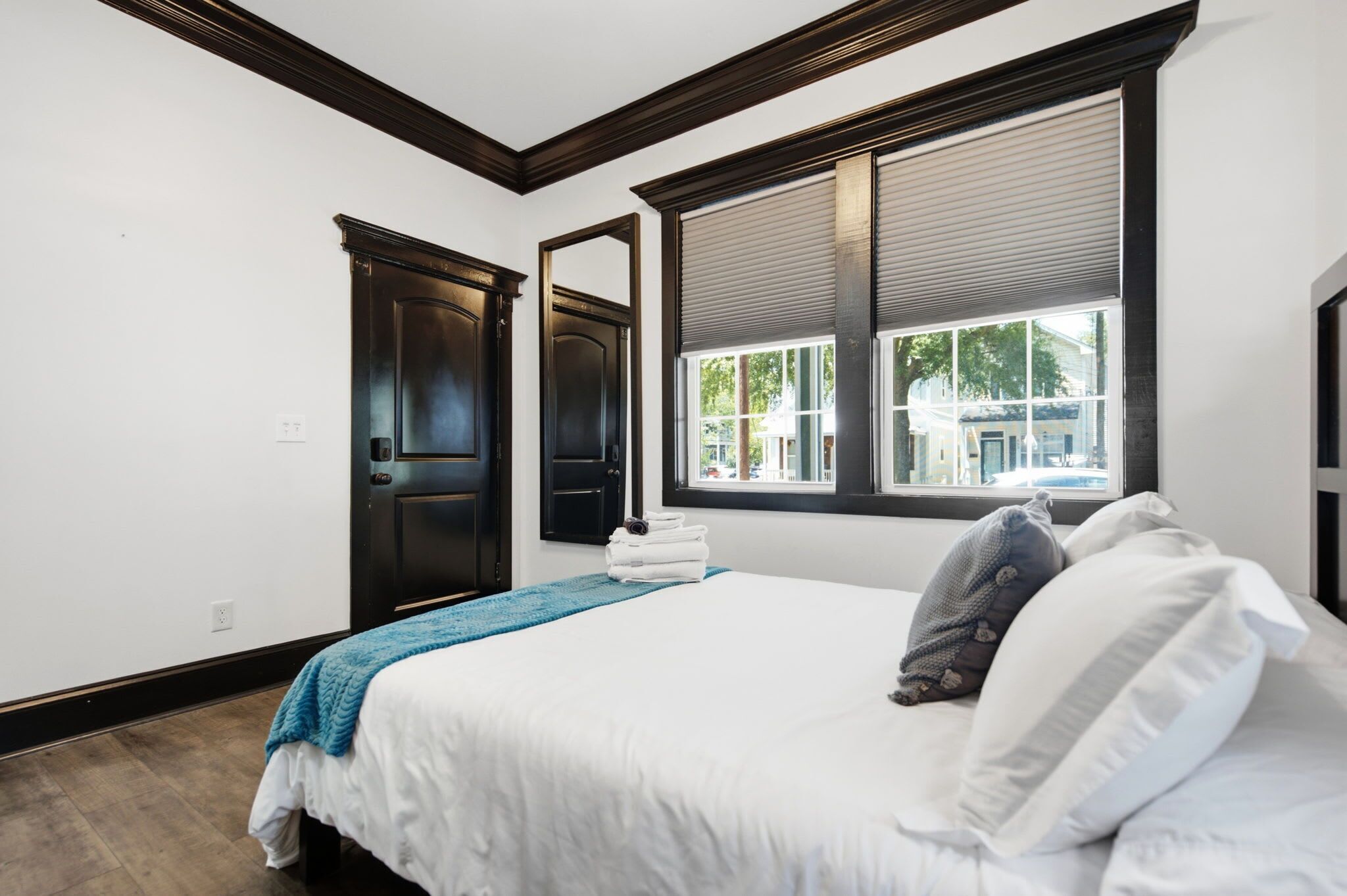 A bedroom with a bed, a window, and a door.
