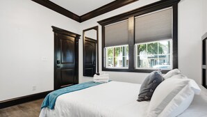 A bedroom with a bed, a window, and a door. - The Jade Getaway in Historic Castle St. District (Wilmington)