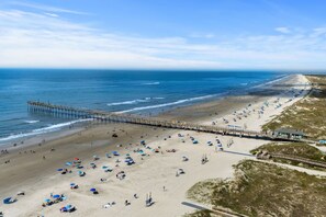 A beach with a pier extending into the ocean, sandy beach, and a clear sky. - Cozy Beach Cottage Near Ocean Isle Beach (Ocean Isle Beach)