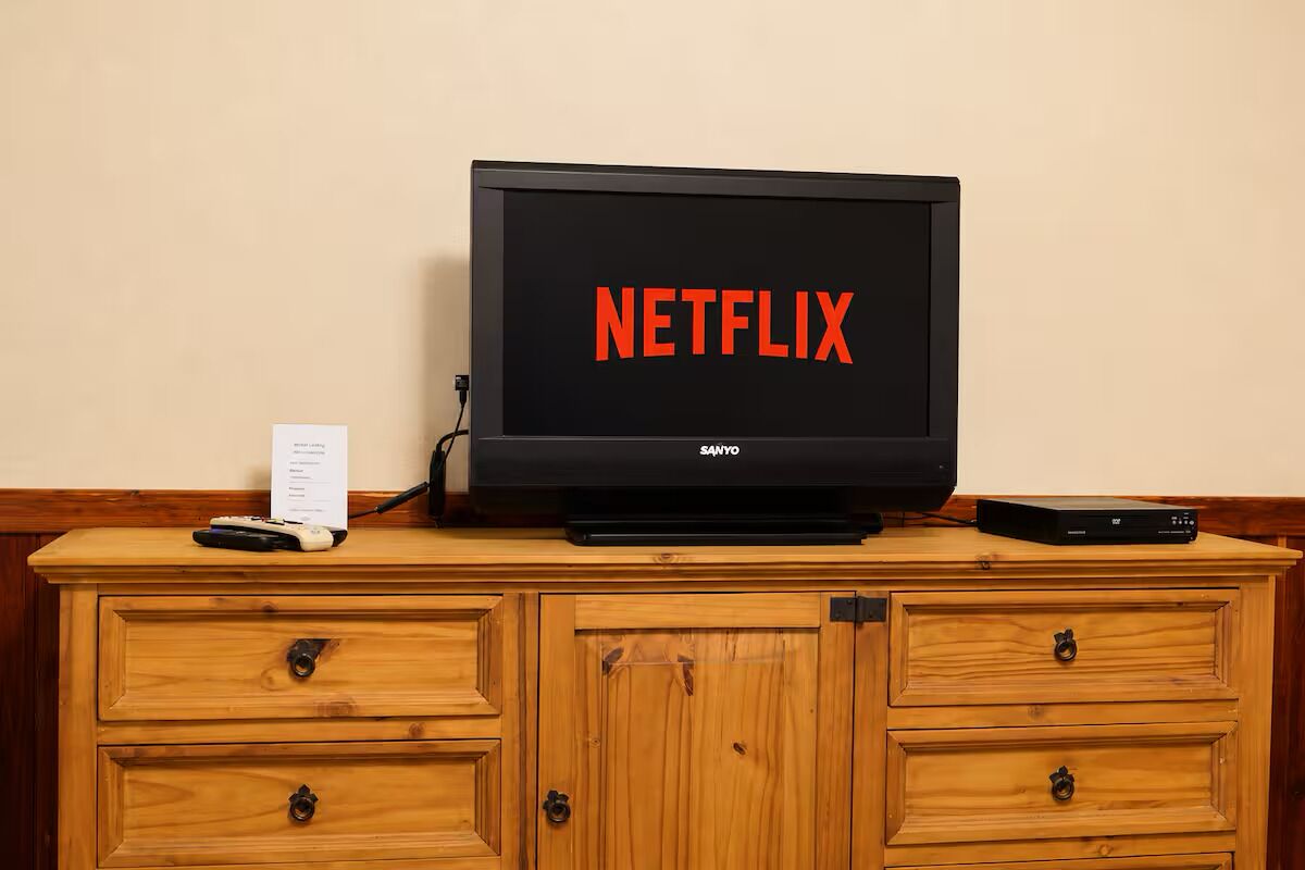 Uma televisão sobre um móvel de madeira com o logotipo da Netflix.