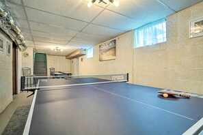 A ping pong table in a room with a textured ceiling, a window with a sheer curtain, and a framed picture on the wall. - 2-Home Country Estate Near Clayton! 2 Hot Tubs (Clayton)