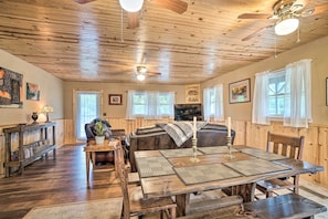 A cozy room with a wooden ceiling, a dining table with placemats, a leather sofa, and a bookshelf. - 2-Home Country Estate Near Clayton! 2 Hot Tubs (Clayton)