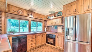 Una cocina con armarios de madera, un refrigerador de acero inoxidable y un lavavajillas.