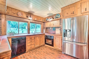A kitchen with wooden cabinets, a stainless steel refrigerator, and a dishwasher. - 2-Home Country Estate Near Clayton! 2 Hot Tubs (Clayton)