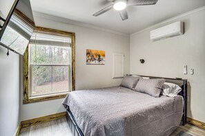 A bedroom with a bed, a ceiling fan, an air conditioning unit, a window with blinds, and a painting on the wall. - Group-Friendly Escape! Gateway to Gulfport Beaches (Gulfport)