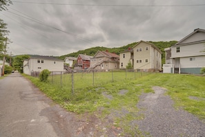 A residential street with houses, a fenced yard, and a gravel path. - Walkable Location! High-End 4-Unit Hinton Getaway (Hinton)