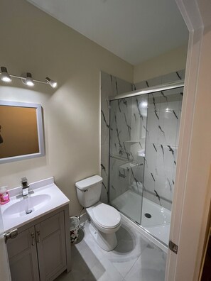 A bathroom with a white sink, a toilet, and a glass-enclosed shower. - Modern & Cozy Stay | Self Check-In | Free Parking (Surrey)
