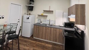 A compact kitchen with a refrigerator, microwave, stove, and a coffee maker. - Modern & Cozy Stay | Self Check-In | Free Parking (Surrey)