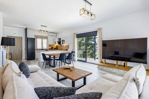 Ein modernes Wohnzimmer mit einer Sofagarnitur, einem Couchtisch und einem Fernseher.