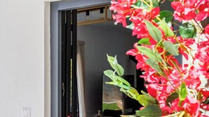 A doorway with a black frame, a light switch, and a reflection of a room with a bed and a window. - Villa Theofilos-Country pool villa-3 bedrooms-wifi-sunset & sea view (Loutraki)