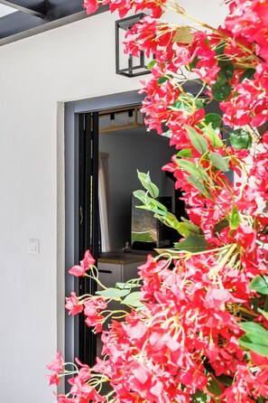 A doorway with a black frame, a light switch, and a reflection of a room with a bed and a window. - Villa Theofilos-Country pool villa-3 bedrooms-wifi-sunset & sea view (Loutraki)