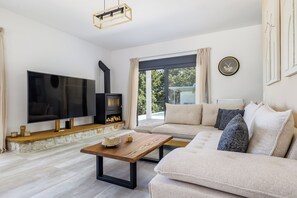 Un salon moderne avec un téléviseur à écran plat, une cheminée, un canapé et une table basse.
