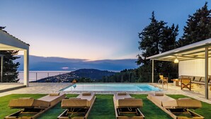 A poolside area with lounge chairs and a view of a mountainous landscape. - Villa Theofilos-Country pool villa-3 bedrooms-wifi-sunset & sea view (Loutraki)