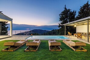 A poolside area with lounge chairs and a view of a mountainous landscape. - Villa Theofilos-Country pool villa-3 bedrooms-wifi-sunset & sea view (Loutraki)