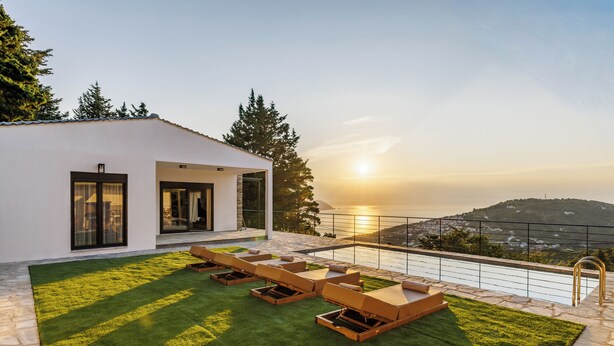 A modern house with a patio area featuring outdoor furniture and a view of the sunset over a valley. - Villa Theofilos-Country pool villa-3 bedrooms-wifi-sunset & sea view (Loutraki)