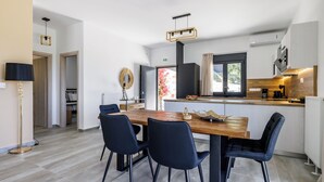A modern kitchen with a wooden island, black chairs, and a dining table. - Villa Theofilos-Country pool villa-3 bedrooms-wifi-sunset & sea view (Loutraki)