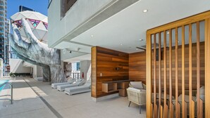 Eine moderne Hotelhalle mit einer großen Skulptur für die Hand, einem Pool und einem hölzernen Empfangsbereich.