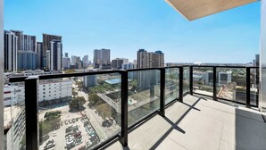 Ein Hochhaus mit Glasbalkon und Blick auf die Stadtlandschaft.