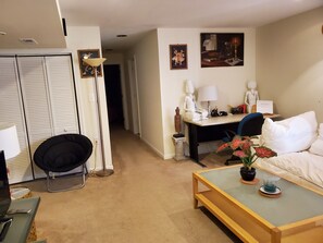 A hotel room with a bed, a desk, a chair, a lamp, and a small table with a plant. - Delightful 2-bedroom Guest Suite with AC in Woodbridge (Woodbridge)