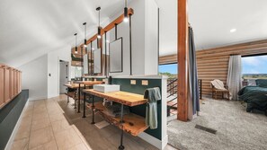 Une salle de bain moderne avec un meuble-lavabo en bois, un grand miroir et une vue sur l’extérieur.