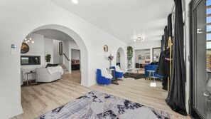 Amplia sala de estar con un ventanal grande, un sofá, una mesa de centro y un sillón azul.